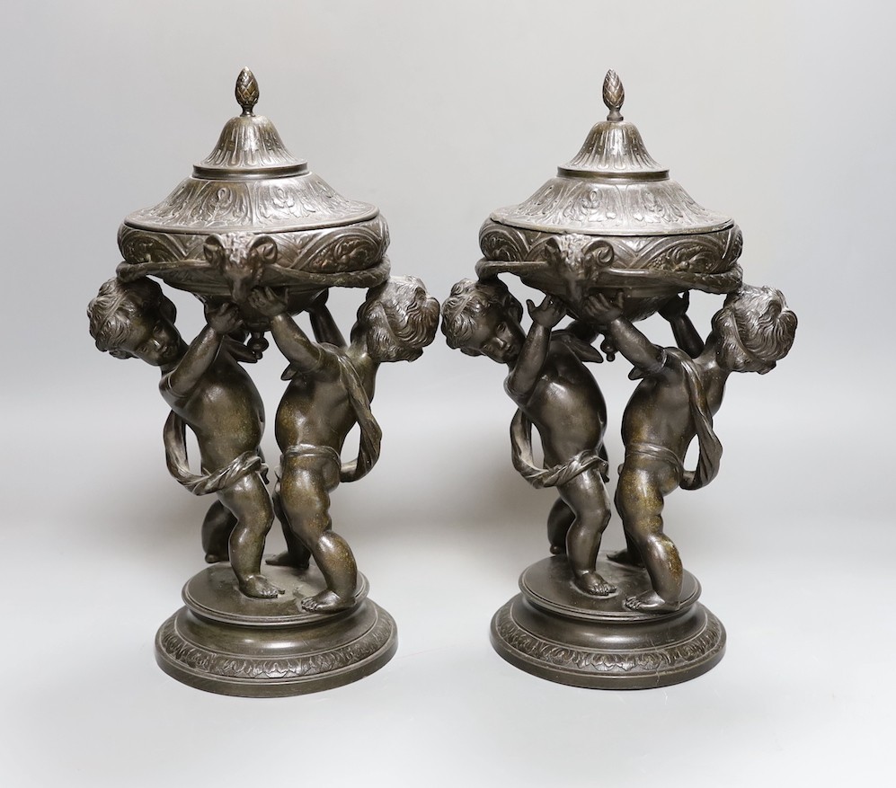 A pair of late 19th century patinated spelter lidded cherubic jars 28cm